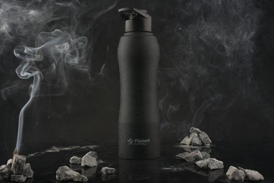 black plastic bottle among rocks and smoke
