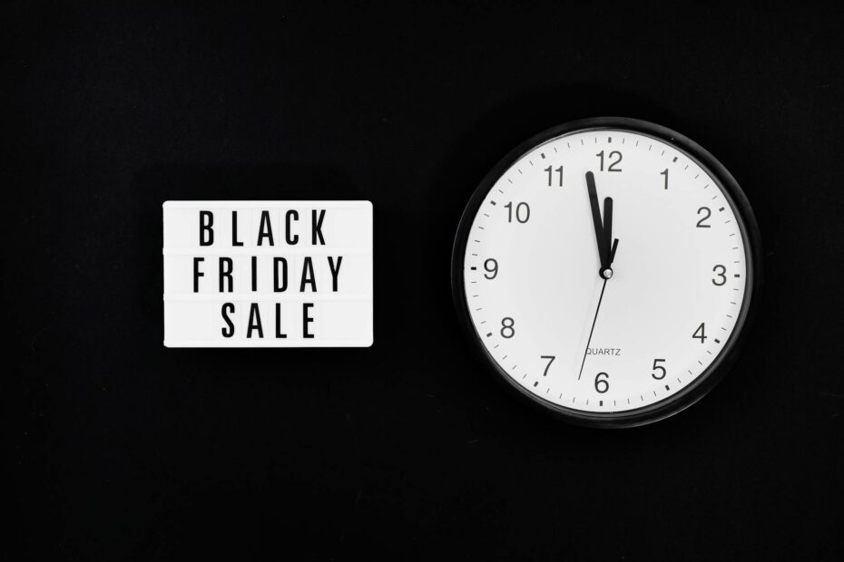 a black friday sale signage beside a black and white round analog wall clock